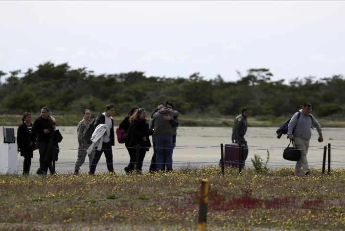 Relatives of passengers of a missing military plane arrive to an airbase in Punta Arenas, Chile, Wednesday, Dec. 11, 2019. Searchers using planes, ships and satellites were combing the Drake Passage on Tuesday, hunting for the plane carrying 38 people that vanished en route to an Antartica base. (AP Photo/Fernando Llano)