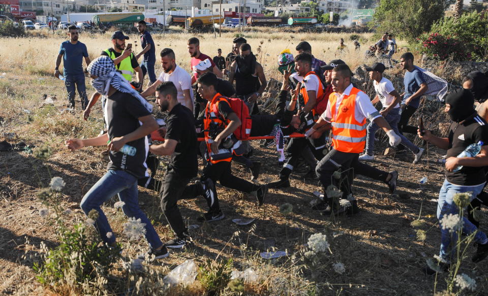 An injured demonstrator is evacuated during an anti-Israel protest, near the Jewish settlement of Beit El near Ramallah, in the Israeli-occupied West Bank, on May 18, 2021. / Credit: AMMAR AWAD / REUTERS