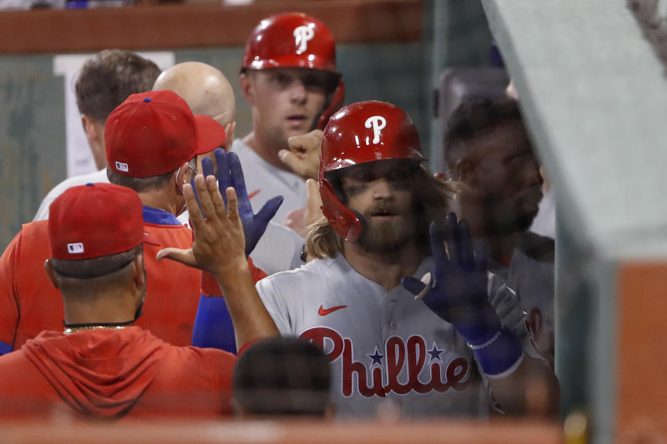 Philadelphia Phillies' Bryce Harper is congratulated in the dugout after hitting a three-run home run against the Boston Red Sox during the sixth inning of a baseball game Tuesday, Aug. 18, 2020, at Fenway Park in Boston. (AP Photo/Winslow Townson)