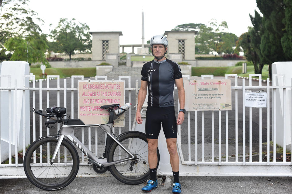 Australian Murray Higgs stands outside the Kranji War Memorial cemetery in his exercise outfit during ANZAC Day, in Singapore Saturday, April 25, 2020. Higgs has lived in Singapore for 20 years and has been attending the annual ANZAC Day dawn service at the cemetery, but this year's commemorative events have been cancelled due to COVID-19 circuit breaker measures being enforced at the city state. (AP Photo/YK Chan)