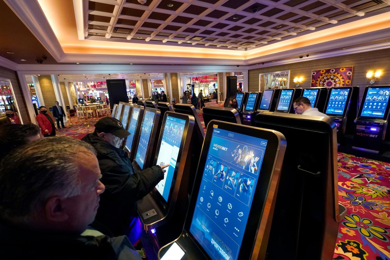 Patrons place sports bets at kiosks at Encore Boston Harbor casino  in Everett.
