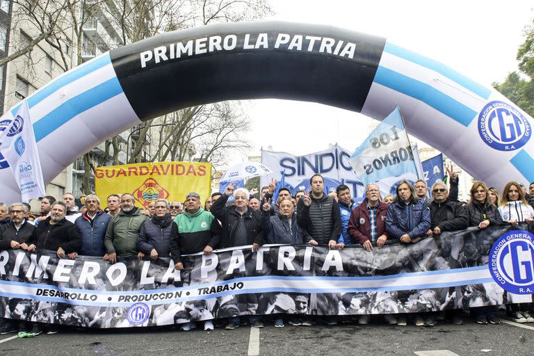 La primera línea de la CGT: Héctor Daer, Carlos Acuña, Pablo Moyano, Julio Piumato, Raúl Durdos, Pablo Flores, Cristian Jerónimo, Omar Plaini y Daniel Ricci sostienen la bandera con la leyenda "Primero la patria"