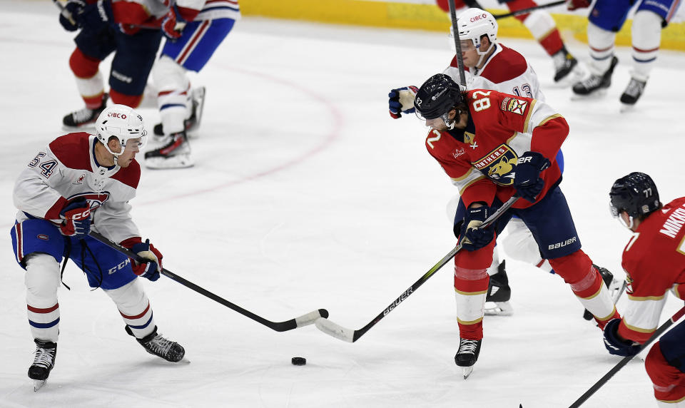 Montreal Canadiens defenseman Jordan Harris (54) tries to control the puck in front of Florida Panthers center Kevin Stenlund (82) during the first period of an NHL hockey game Saturday, Dec. 30, 2023, in Sunrise, Fla. (AP Photo/Michael Laughlin)