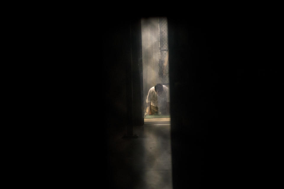 FILE - In this June 6, 2018 photo, reviewed by U.S. military officials, a detainee, name and facial identification not permitted, prays inside the Camp VI detention facility at Guantanamo Bay U.S. Naval Base, Cuba. The 20th anniversary of the first prisoners' arrival at the Guantanamo Bay detention center is on Tuesday, Jan. 11, 2022. There are now 39 prisoners left. At its peak, in 2003, the detention center held nearly 680 prisoners. (AP Photo/Ramon Espinosa, File)