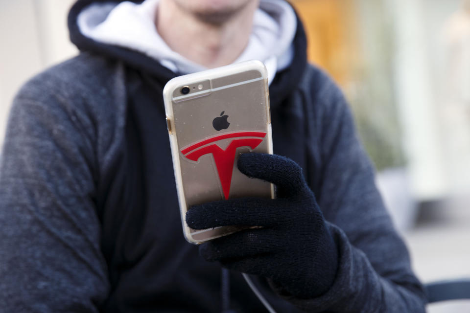 The Tesla Motors Inc. logo is seen on the Apple Inc. iPhone case of a customer waiting in line ahead of the Model 3 announcement outside the Tesla Motors Inc. store on the Third Street Promenade in Santa Monica, California, U.S., on Wednesday, March 30, 2016. (Photo: Patrick T. Fallon/Bloomberg)