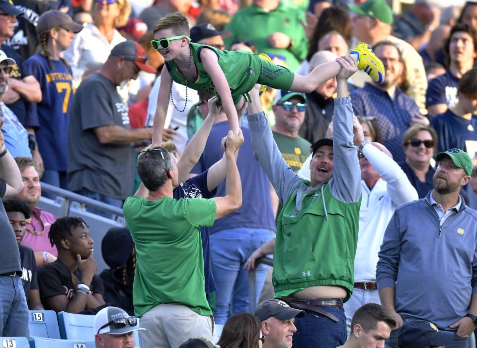 Notre Dame fans lift a young fan into the air after a Fighting Irish touchdown during first-half action. The University of Notre Dame Fighting Irish took on the University of South Carolina Gamecocks in the TaxSlayer Gator Bowl game in Jacksonville, Florida’s TIAA Bank Field Friday, December 30, 2022. The first half ended with <a class="link " href="https://sports.yahoo.com/ncaaf/teams/south-carolina/" data-i13n="sec:content-canvas;subsec:anchor_text;elm:context_link" data-ylk="slk:South Carolina;sec:content-canvas;subsec:anchor_text;elm:context_link;itc:0">South Carolina</a> holding a 24 to 17 lead. [Bob Self/Florida Times-Union]<br>Jki 123022 Bs Gatorbowl 35