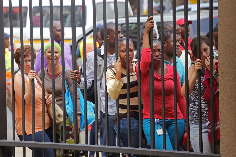 People try to get a view of Oscar Pistorius, during a lunch break from outside the high court, on the fourth day of his trial in Pretoria, South Africa, Thursday, March 6, 2014. Pistorius is charged with murder in the shooting death of girlfriend Reeva Steenkamp in the pre-dawn hours of Valentine's Day 2013. (AP Photo/Schalk van Zuydam)