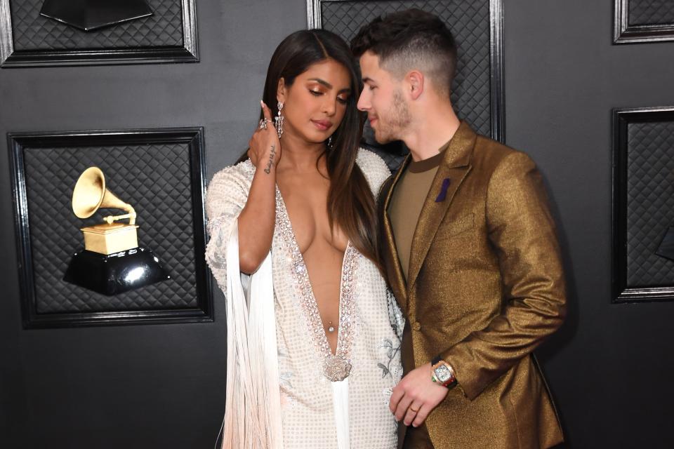 Indian actress Priyanka Chopra (L) and US singer-songwriter Nick Jonas look at each other as they arrive for the 62nd Annual Grammy Awards on January 26, 2020, in Los Angeles.