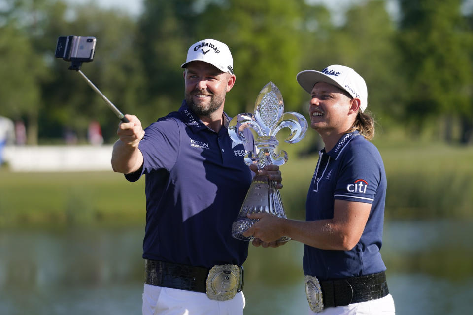 Marc Leishman, of Australia, left, and teammate Cameron Smith, of Australia, hold the trophy after winning the PGA Zurich Classic golf tournament at TPC Louisiana in Avondale, La., Sunday, April 25, 2021. (AP Photo/Gerald Herbert)