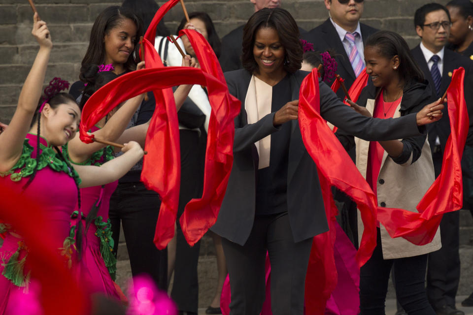First lady Michelle Obama dances with performers during her visit to an ancient city wall with her daughters Malia and Sasha in Xi'an, in northwestern China's Shaanxi province, Monday, March 24, 2014. 