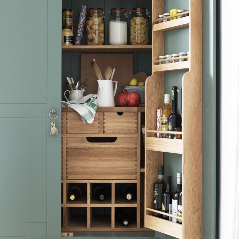 wooden shelving inside green painted kitchen pantry