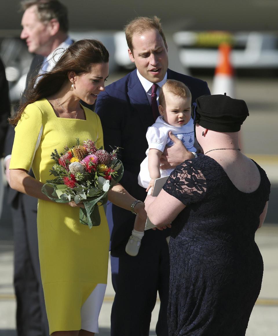Britain's Prince William back right, and his wife Kate, the Duchess of Cambridge, along with their son Prince George are presented with flowers by Joscelyn Sweeney upon arriving in Sydney, Australia, Wednesday, April 16, 2014. The Duke and Duchess of Cambridge are on a three-week tour of Australia and New Zealand, the first official trip overseas with their son, Prince George. (AP Photo/Rob Griffith)