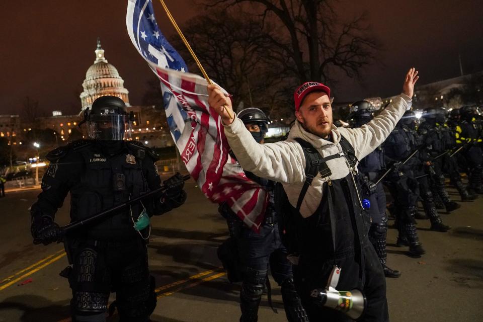 A police line moves a protestor outside of the Capitol, Wednesday night, Jan. 6, 2021, after a day of rioting protesters.