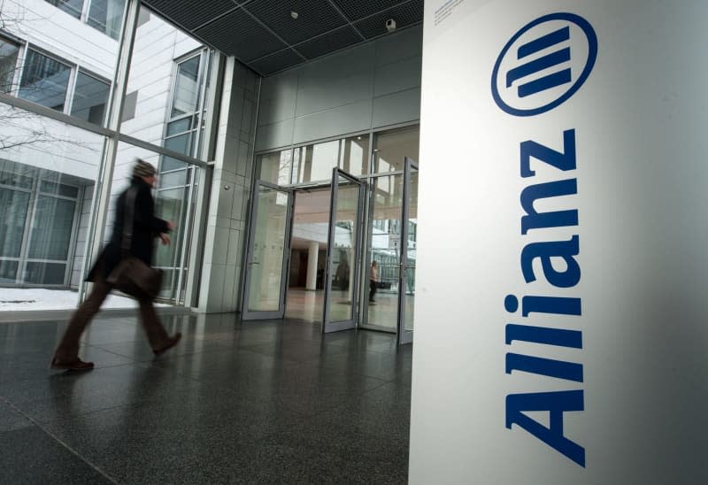 A man walks past the Allianz logo in Munich. Armin Weigel/dpa