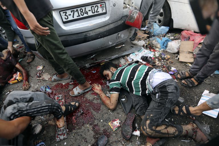 Palestinos muertos y heridos en el terreno luego de un ataque aéreo israelí afuera de la entrada del hospital al-Shifa en la ciudad de Gaza (AP/Abed Khaled)