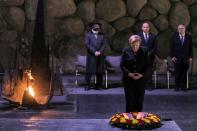 German Chancellor Angela Merkel pauses after laying a wreath in the Hall of Remembrance at the Yad Vashem Holocaust Museum in Jerusalem as Israeli Prime Minister Naftali Bennett looks on (AFP/Gil COHEN-MAGEN)