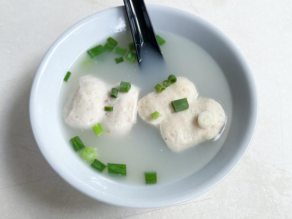 Flat shaped pork balls are served with a milky pork bone broth