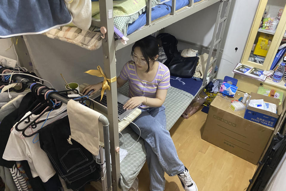 Recent college graduate Liu Qian works on her laptop computer in the room she rents in an apartment in Beijing, Thursday, July 7, 2022. Liu is one of 11 million new graduates desperate for work in a bleak job market as anti-virus controls force factories, restaurants and other employers to close. The survivors are cutting jobs and wages. (AP Photo/Olivia Zhang)