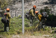 Firefighters mop up hotspots from a back fire near the Yosemite National Park south entrance, as the Washburn Fire continues to burn, Tuesday, July 12, 2022, in Calif. (AP Photo/Godofredo A. Vásquez)