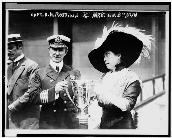 British merchant seaman Sir Arthur Henry Rostron (1869 - 1940) (center), captain of the RMS Carpathia, is presented with a trophy cup by American socialite Molly Brown (1867 - 1932), New York, New York, May 29, 1912. The Carpathia had been instrumental in the rescue of 705 passengers, one of whom was Brown, from the sinking RMS Titanic the previous month. (Photo by Bain Photo Collection/PhotoQuest/Getty Images)