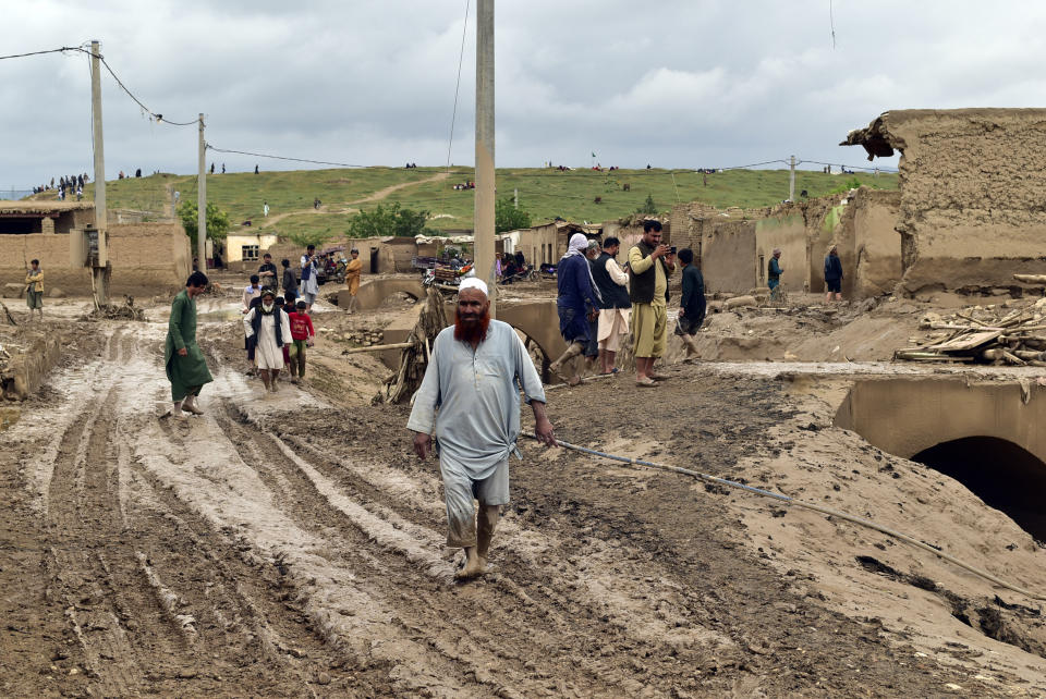 People gather around their damaged houses after heavy flooding in Baghlan province in northern Afghanistan Saturday, May 11, 2024. Flash floods from seasonal rains in Baghlan province in northern Afghanistan killed dozens of people on Friday, a Taliban official said. (AP Photo/Mehrab Ibrahimi)