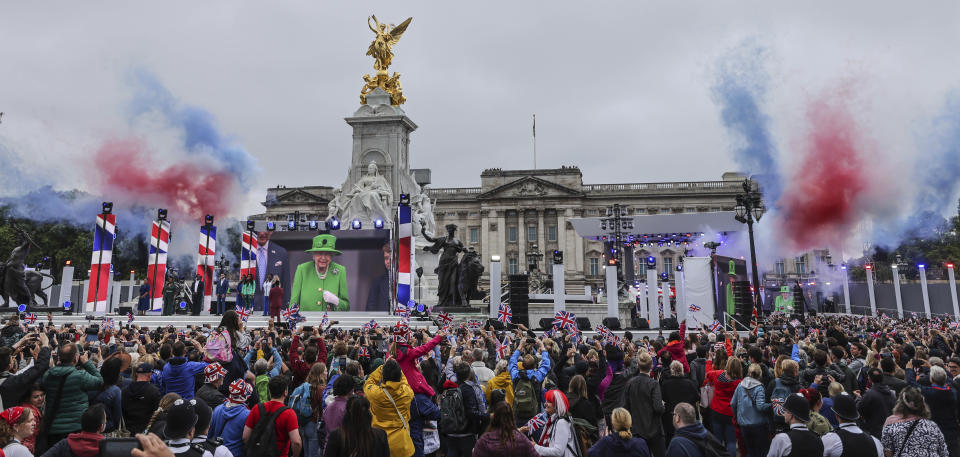 People react as Queen Elizabeth II appears on the balcony of Buckingham Palace in London, Sunday June 5, 2022, on the last of four days of celebrations to mark the Platinum Jubilee. The Platinum Jubilee Pageant will be a carnival procession up The Mall featuring giant puppets and celebrities that will depict key moments from the Queen Elizabeth II's seven decades on the throne. (Richard Pohle/Pool Photo via AP)