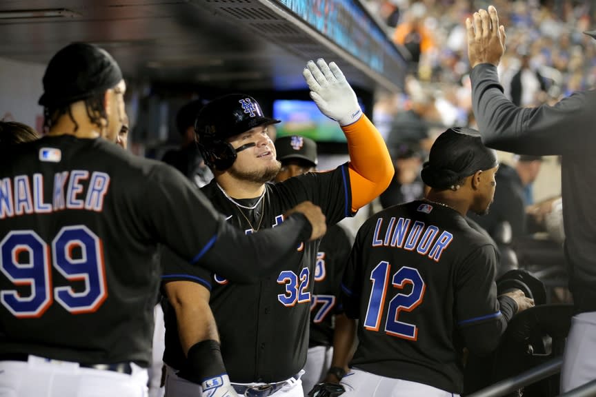 New York Mets designated hitter Daniel Vogelbach (32) celebrates his solo home run against the Pittsburgh Pirates in the dugout with teammates during the fourth inning at Citi Field.