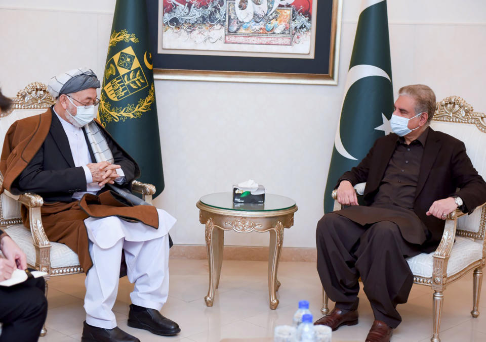 In this photo provided by Pakistan's Ministry of Foreign Affairs, Karim Khalili, left, an influential Afghan Shiite leader, meets with Pakistani Foreign Minister Shah Mahmood Qureshi at Foreign Ministry in Islamabad, Pakistan, Tuesday, Jan. 12, 2021. Khalili is visiting Pakistan where members of the minority sect are still reeling from the brutal killing of 11 Shiite coal miners, nine of whom were Afghan immigrants, earlier this month. (Ministry of Foreign Ministry via AP)