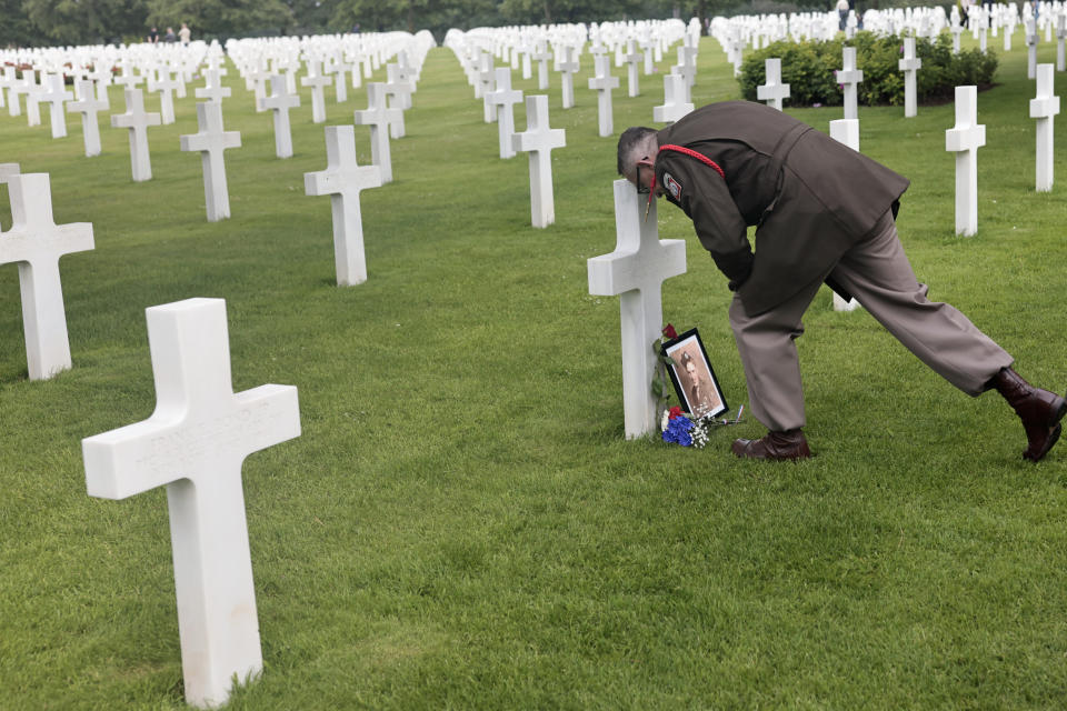 World War II history enthusiast Arnauld Villalard marks respect on a headstone in the US cemetery of Colleville-sur-Mer, Normandy, Saturday, June, 4 2022. Several ceremonies will take place to commemorate the 78th anniversary of D-Day that led to the liberation of France and Europe from the German occupation. (AP Photo/Jeremias Gonzales)