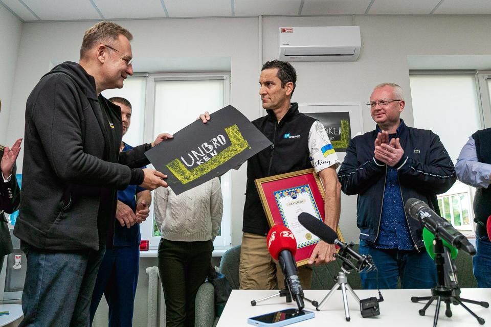 Lviv Mayor Andriy Sadovyi, left, presents JustAnswer CEO Andy Kurtzig, center, with gifts during the grand opening of a mental health center in the Ukrainian city in October 2022. Kurtzig's nonprofit helped fund the center, which opened eight months after Russia invaded Ukraine. Kurtzig's company has dozens of employees still working in Ukraine.