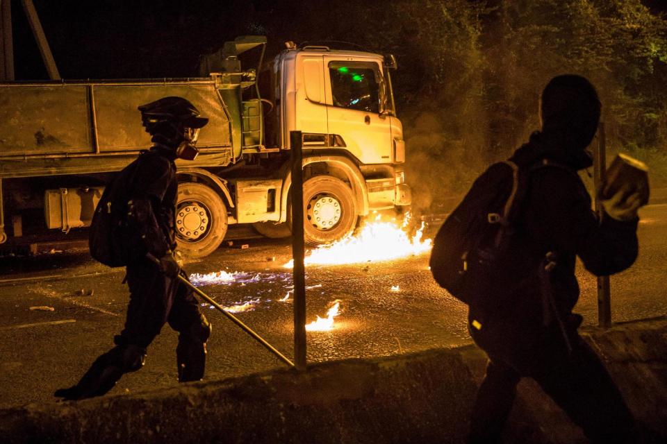 Molotov cocktail thrown by protester burns next to truck during night of intense clashes (AFP via Getty Images)