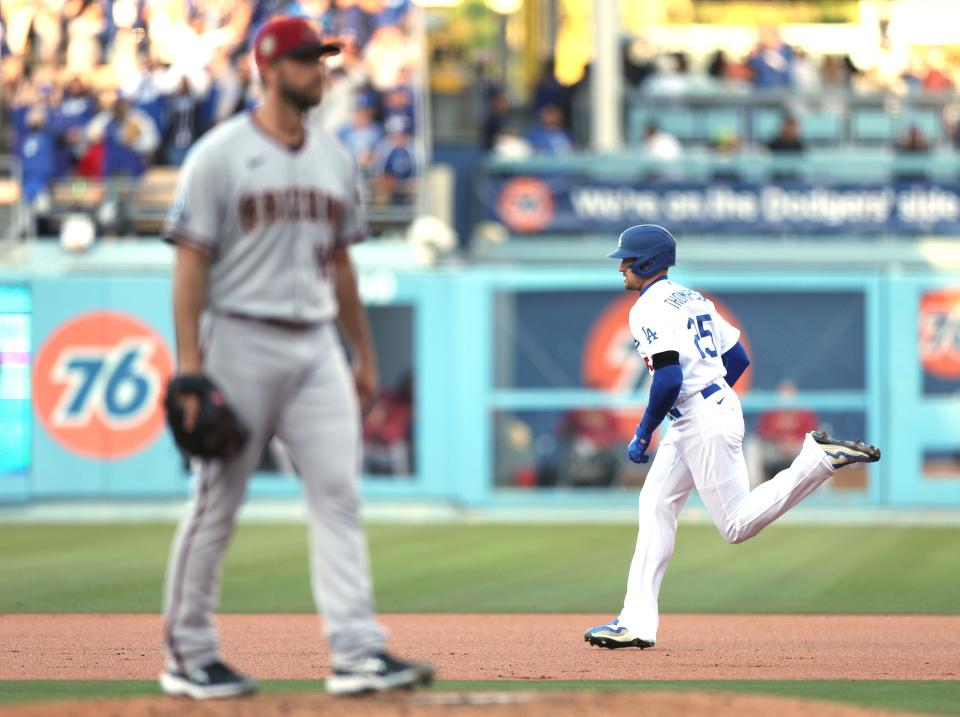 Trayce Thompson (25) of the Los Angeles Dodgers runs past Madison Bumgarner of the Arizona Diamondbacks after his grand slam homerun, to take a 5-0 lead, during the first inning at Dodger Stadium on April 01, 2023, in Los Angeles.