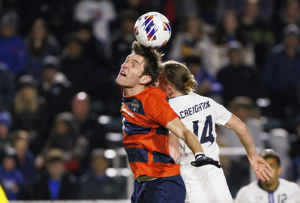 Syracuse's Jeorgio Kocevski and Creighton's Callum Watson (14) go for a head ball during the second half of an NCAA men's soccer tournament semifinal in Cary, N.C., Friday, Dec. 9, 2022. (AP Photo/Ben McKeown)