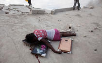 Una niña de 15 años yace muerta en el suelo tras recibir un disparo por el saqueo de una tienda de tapices en Puerto Príncipe, el 10 de enero del 2010 (REUTERS/Carlos Garcia Rawlins).