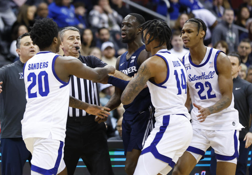 An official steps in to break up a scuffle between Seton Hall guard Jaquan Sanders (20) and Xavier guard Souley Boum during the second half of an NCAA college basketball game in Newark, N.J., Friday, Feb. 24, 2023. (AP Photo/Noah K. Murray)