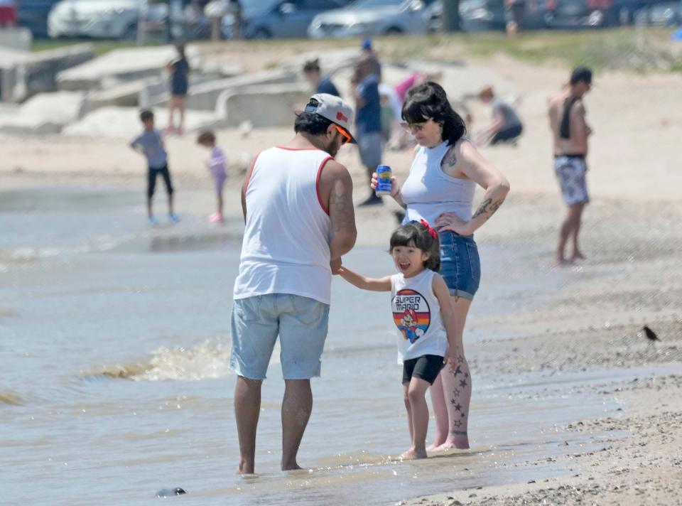 Justin Howe and his wife Joni Howe, of Milwaukee, spend time with their 4-year-old daughter, Marley at Bradford Beach on North Lincoln Memorial Drive in Milwaukee on Thursday.