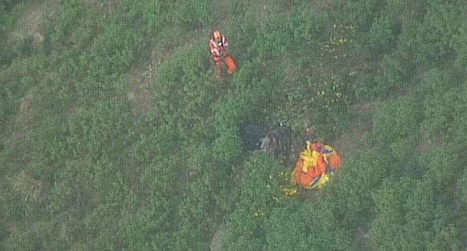 Emergency crews reach a paraglider who was killed after taking off from a popular gliding spot south of Sydney where he collided into a cliff. Source: ABC