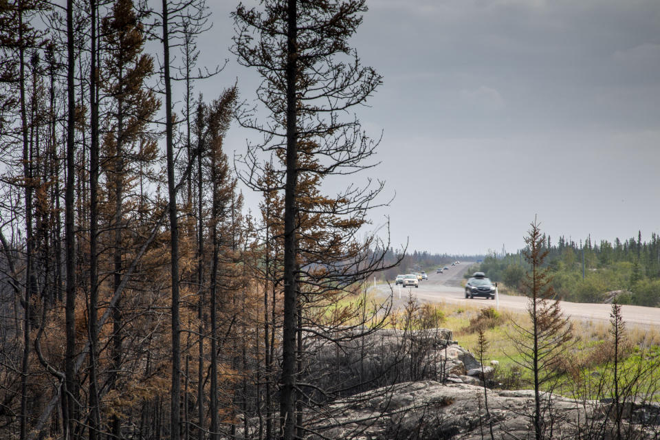 Evacuees from Yellowknife, territorial capital of the Northwest Territories, make their way along highway 3, at the edge of a burned forest, on their way into Ft. Providence, N.W.T., Thursday, Aug. 17, 2023. (Bill Braden /The Canadian Press via AP)