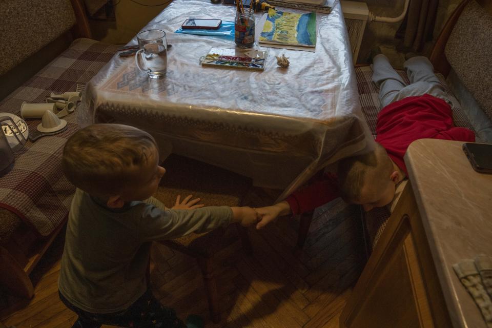 Makar, and his 6-year-old brother Nazar, play at an apartment where they took refuge after fleeing their home in Kyiv, given to them by a cousin, in Lviv, western Ukraine, Saturday, April 2, 2022. The family wants to stay in Ukraine, but they have no long-term plan. (AP Photo/Nariman El-Mofty)