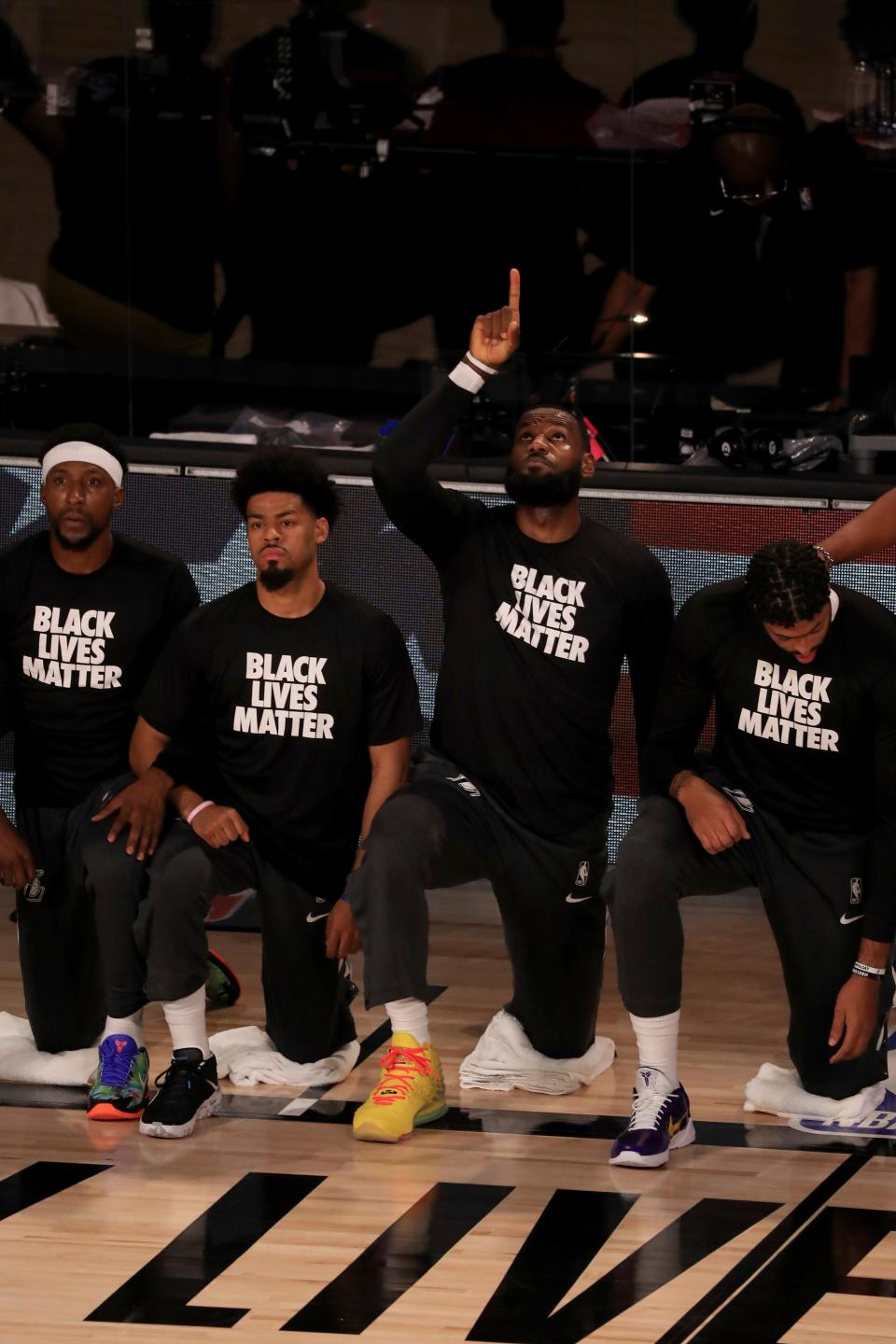 Los Angeles Lakers' LeBron James wears a Black Lives Matter shirt as he points up and kneels with teammates during the national anthem prior to an NBA basketball game against the Los Angeles Clippers, Thursday, July 30, 2020, in Lake Buena Vista, Fla. (Mike Ehrmann/Getty Images via AP, Pool)