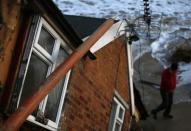 A garden gnome sits on the window of a house that fell into the sea during a storm surge in Hemsby, eastern England December 6, 2013. REUTERS/Darren Staples