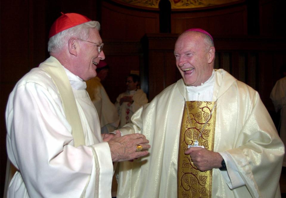 FILE - In this Jan. 21, 2001 file photo, Cardinal-designate Theodore E. McCarrick, right, is congratulated by Cardinal William Keeler of Baltimore before a Sunday evening Mass at the Basilica of the National Shrine of the Immaculate Conception in Washington. Pope John Paul II elevated McCarrick, the current archbishop of Washington, to cardinal. (AP Photo/Susan Walsh, File)