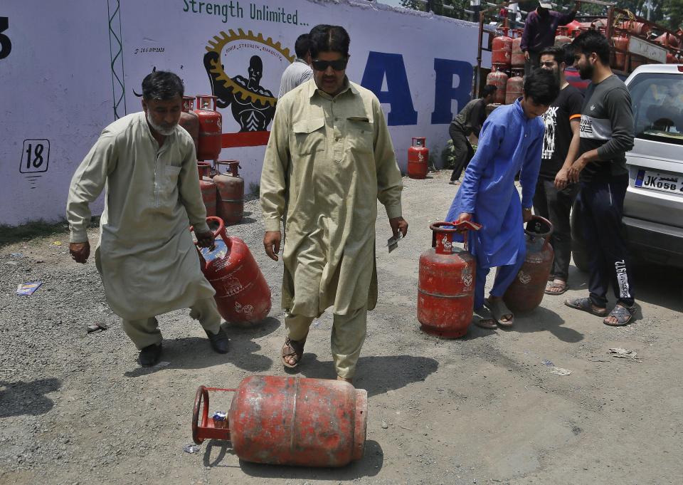 Kashmiri residents take home cooking gas cylinders after buying them in Srinagar, India, Sunday, Aug. 4, 2019. People in Srinagar and other towns in Indian Kashmir thronged grocery stores and medical shops to stock up on essentials. Tensions have soared along the volatile, highly militarized frontier between India and Pakistan in the disputed Himalayan region of Kashmir as India deployed more troops and ordered thousands of visitors out of the region. (AP Photo/Mukhtar Khan)