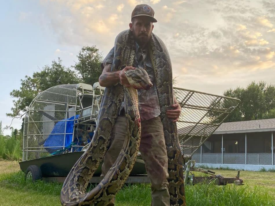 Mike Kimmel with the 17 foot long snake: (Martin County Trapping & Wildlife Rescue - Facebook)