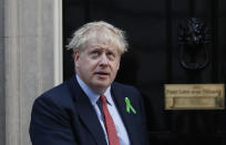 Britain's Prime Minister Boris Johnson looks up from the doorstep of 10 Downing Street in London, Thursday, Oct. 10, 2019. Johnson was meeting mental health campaigners, whose badge he wears and later Thursday he is scheduled to meet with Irish Prime Minister Leo Varadkar for talks on Brexit. (AP Photo/Alastair Grant)