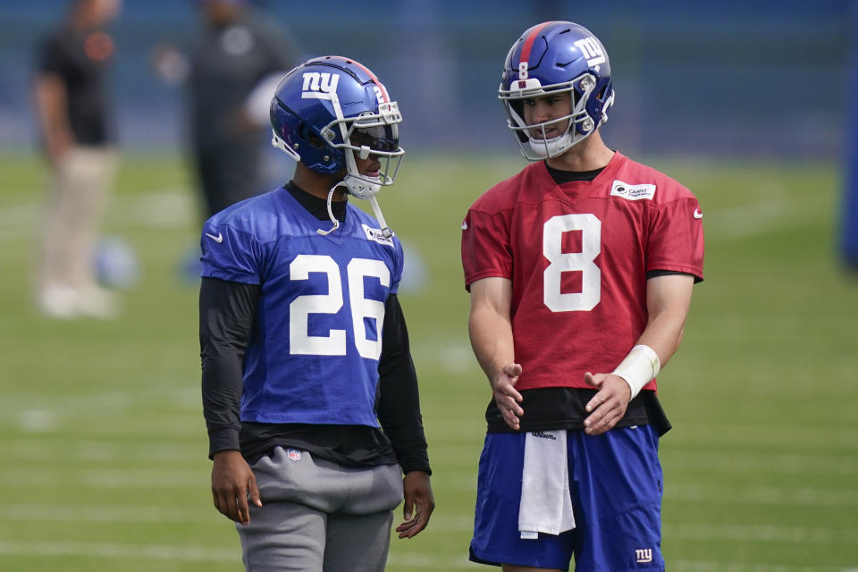 FILE - New York Giants' quarterback Daniel Jones, right, talks with Saquon Barkley during a practice at the NFL football team's training facility in East Rutherford, N.J., May 26, 2022. Jones is entering the final season of his contract and needs to step up to get a new one. Barkley has looked very good in training camp in his second season after a major knee injury. They have been the mainstays of the Giants offense for the last three years. (AP Photo/Seth Wenig, File)