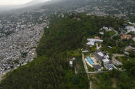 Swathes of green separate the densely populated Jalousie neighborhood from the wealthy suburb Petion-Ville, in Port-au-Prince, Haiti, Monday, Oct. 4, 2021. Some of Haiti’s wealthy elite can trace roots to ancestors who came to the country generations ago and built fortunes. Today there is a constant struggle to keep their business going in the face of threats and extortion by the gangs that rule a country where government has ceased to function. (AP Photo/Rodrigo Abd)