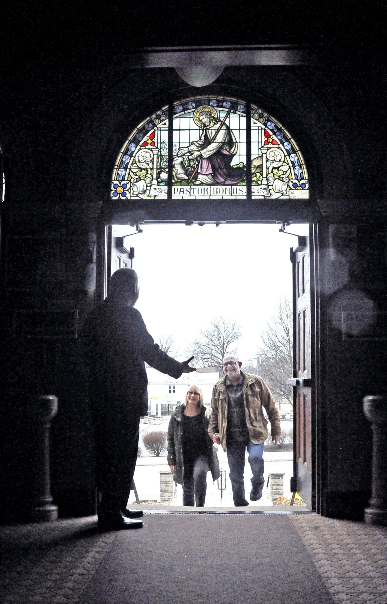 Father Rich Samide (left) welcomes Rich Harsh (right) and his wife, Laurie, to St. Mary of the Immaculate Conception Catholic Church in Wooster in 2020. Rich Harsh went through the Catholics Returning Home program at St. Mary, and Laurie is now joining the Catholic church, too.