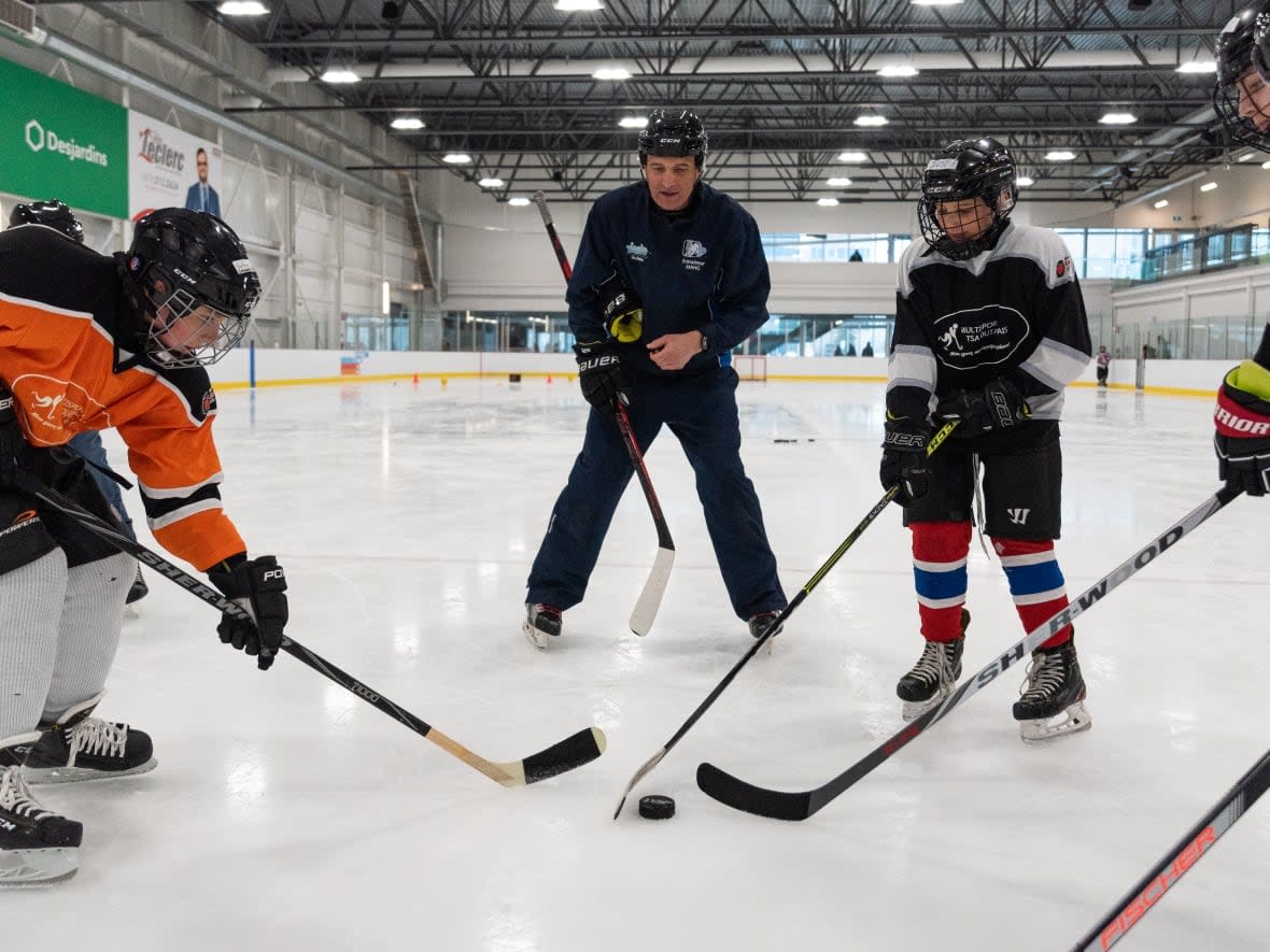 Young hockey players face off in Gatineau, Que., in March. Many hockey parents were outraged after learning that part of player registration fees went toward a controversial reserve fund Hockey Canada used to pay out millions of dollars for sexual assault allegations.  (Alexander Behne/Radio-Canada - image credit)