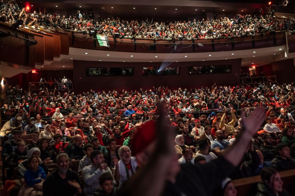 A crowd of Arab Americans cheer on the Moroccan soccer team during a World Cup semifinal match against France as the game was screened at the Ford Community and Performing Arts Center in Dearborn on Dec. 14, 2022.